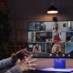 a microsoft teams video call is going on with a team of people virtually by a person