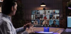 a microsoft teams video call is going on with a team of people virtually by a person
