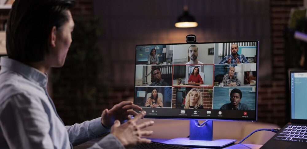a microsoft teams video call is going on with a team of people virtually by a person